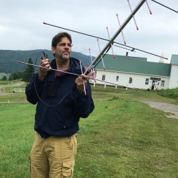 a man outside holding portable antenna