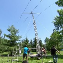 men erecting a large portable ham radio antenna