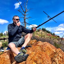 ham operator using a portable radio antenna on hilltop