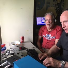 two men using a small portable ham radio station