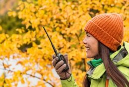 a young woman using a handheld radio