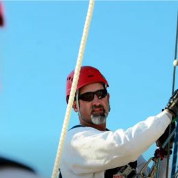 workers talking while climbing a tall antenna tower