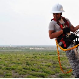 repair worker climbing a tall radio tower