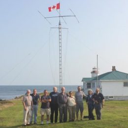 people standing near a ham radio antenna outside