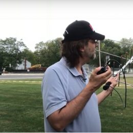 man holding a ham radio antenna outdoors