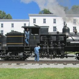 woman standing next to old steam locomotive