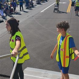kids in vests near a parade event
