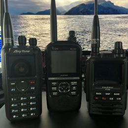 group of three ham radio HTs on a desk