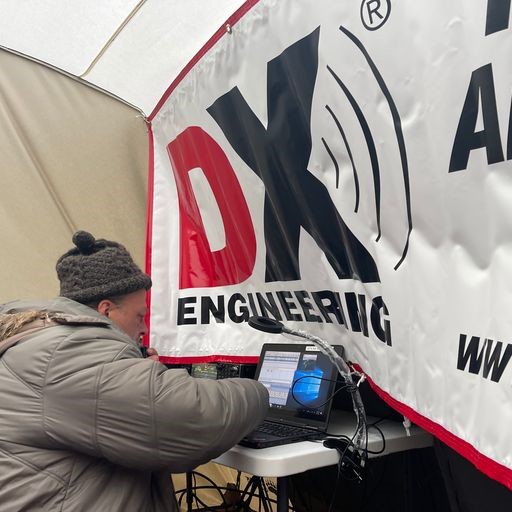 Photo of Yuri, N3QQ, operating CW with a DX Engineering banner in front. DX Engineering was an equipment sponsor of K7K.