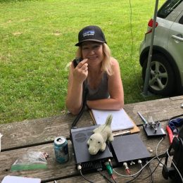 woman using ham radio at an outdoor portable station