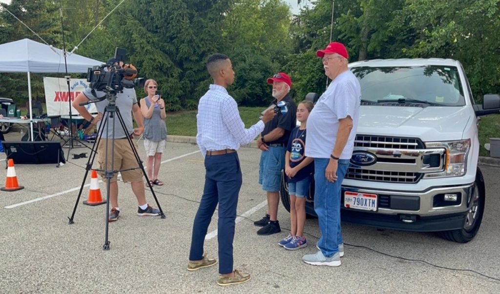 Man getting interviewed by media, Field Day