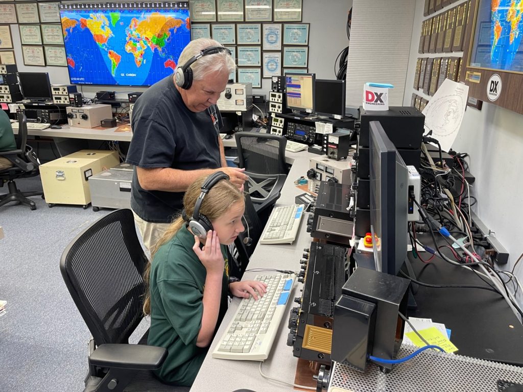 a ham radio elmer teaching a young amateur radio operator