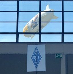 blimp being pictured through a window of a convention center