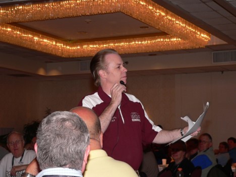 Man speaking to a crowd with a mic