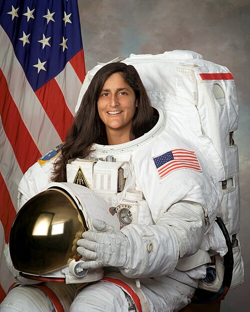 an astronaut posing in space suit for press photo