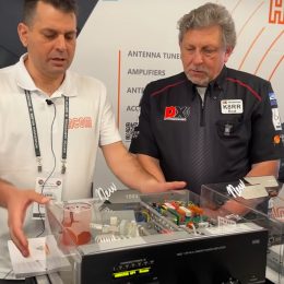 2 men talking near an rf amplifier