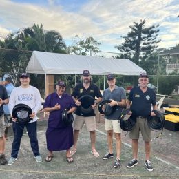 group of men outside holding coaxial cable