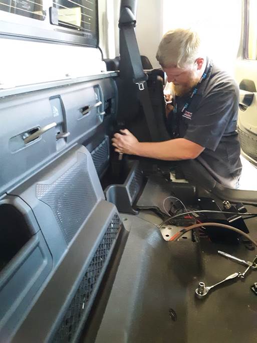 man removing rear seat panel in a Jeep gladiator