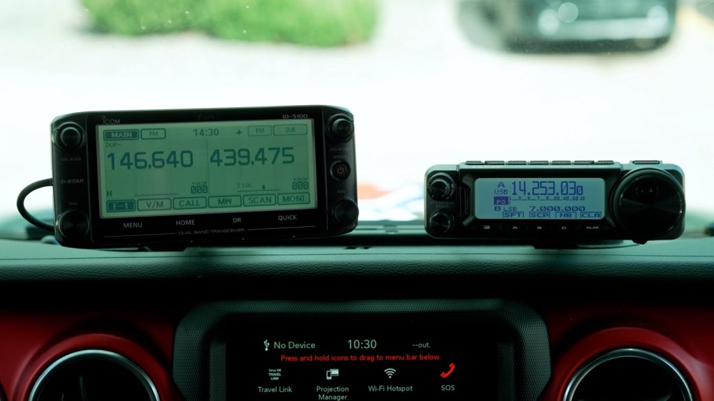 a pair of ham radio control units on dash of a jeep