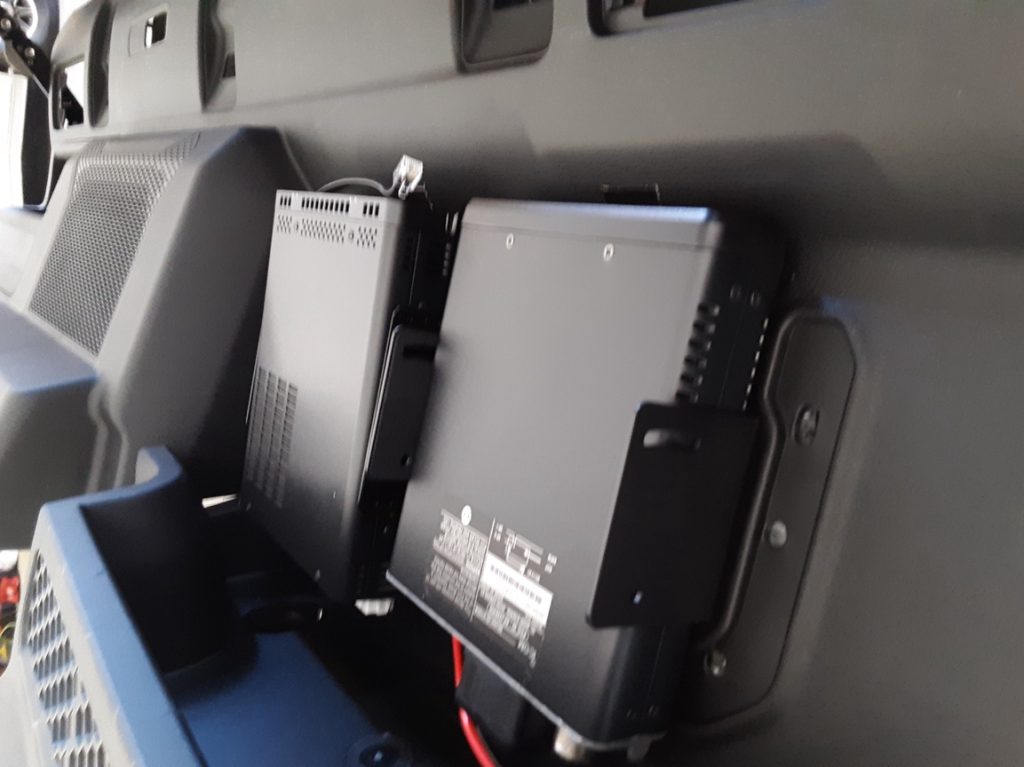 a pair of radio transceivers mounted to rear seat panel