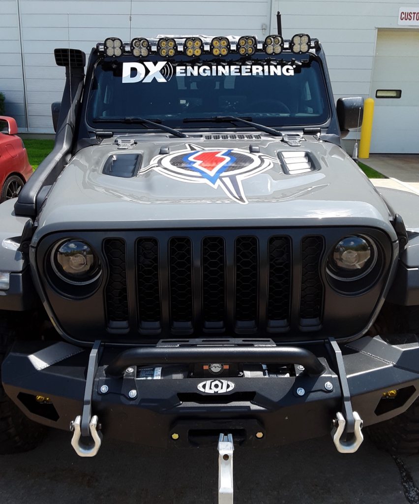 front view of a jeep with extra lights & a winch