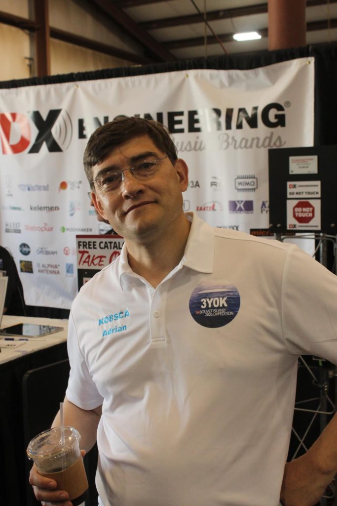 man posing in front of a dxpedition banner