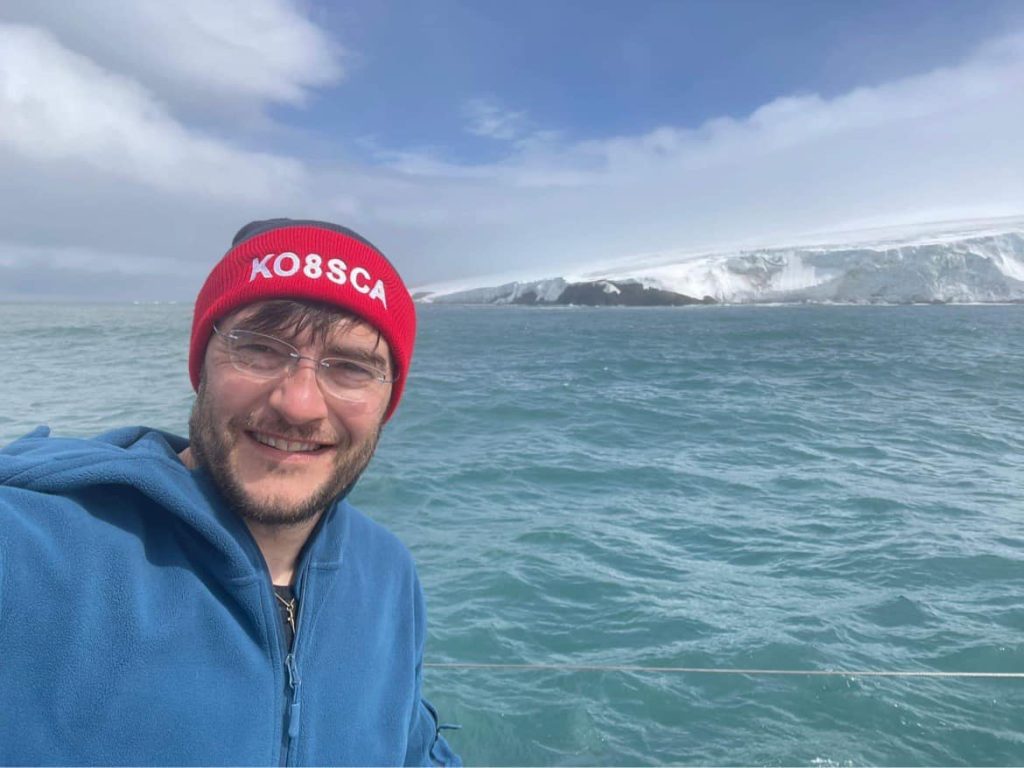 Man taking a selfie on a boat near remote island