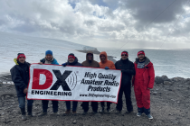 Men on a remote beach holding a large banner