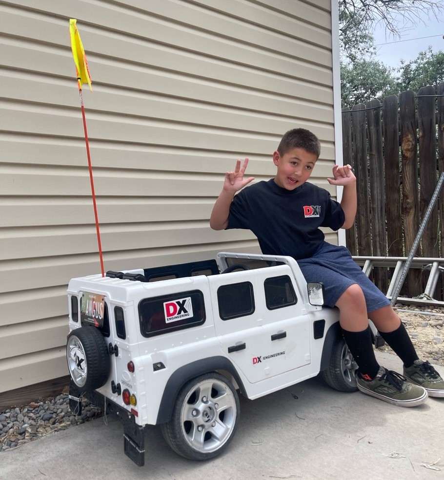 Young boy sitting on a power wheel Land Rover
