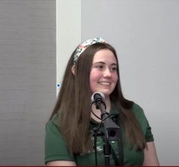 young woman behind a microphone