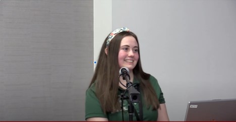 young woman behind a microphone