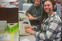 2 operators sitting at a ham radio station desk