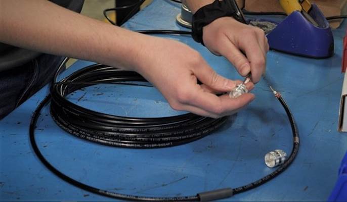 person assembling coaxial cable