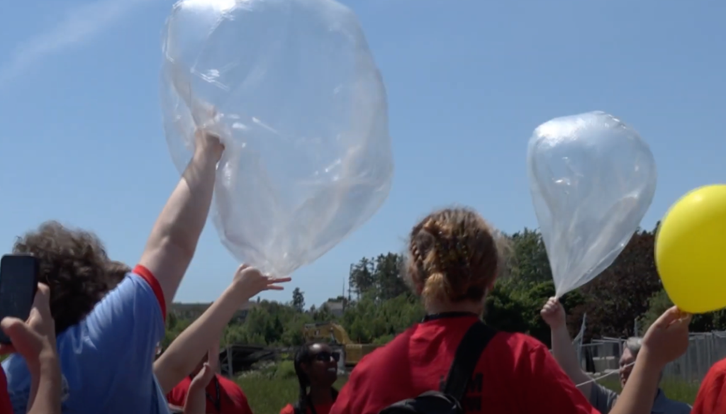 releasing a large weather balloon into the sky