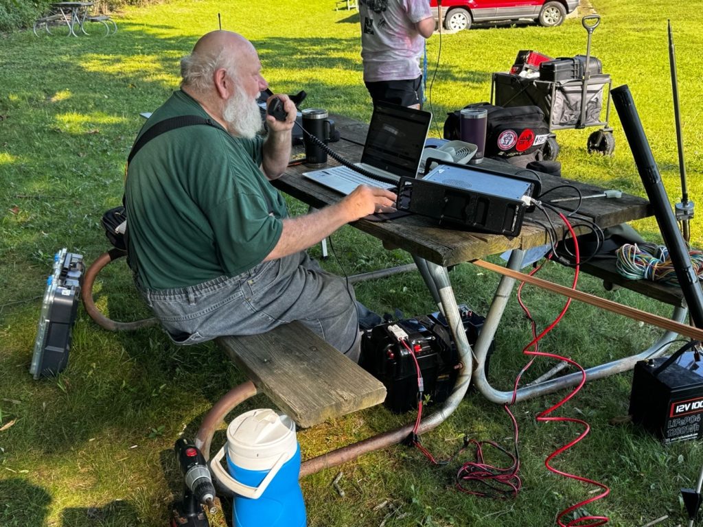 ham radio operator at a picnic table portable field day station