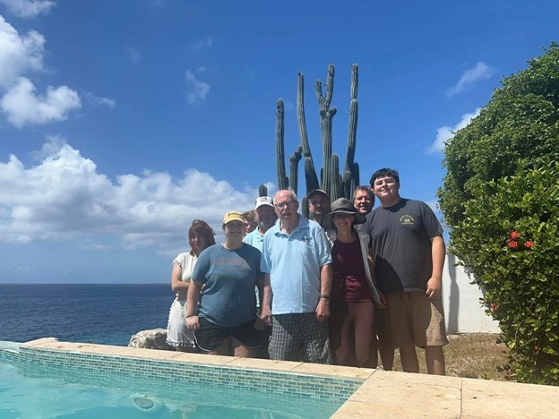 a group of people posing in front of a cactus