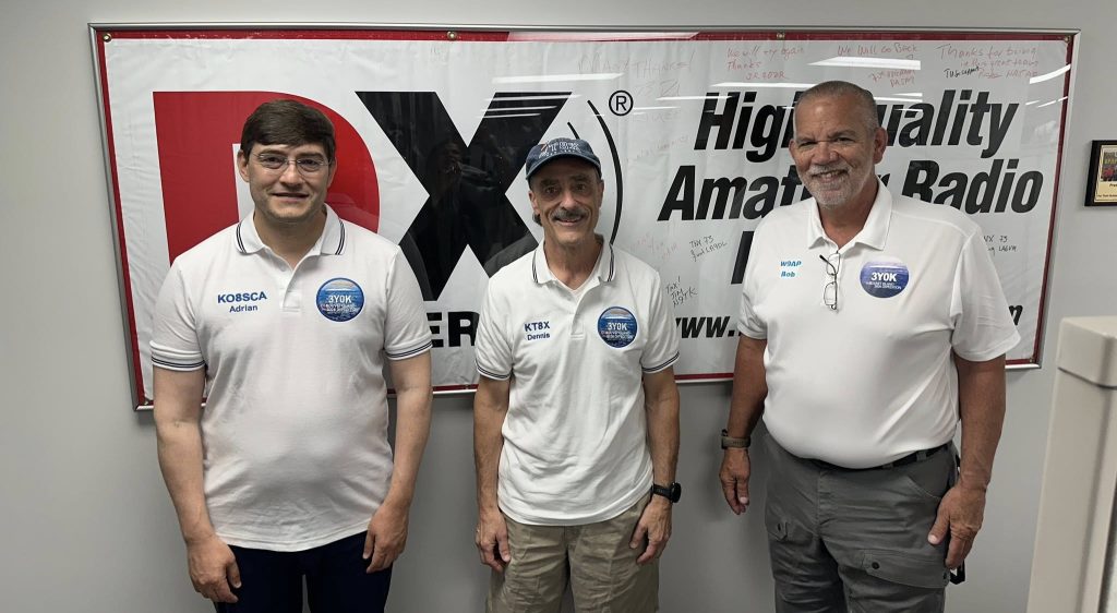 men standing in front of an autographed banner
