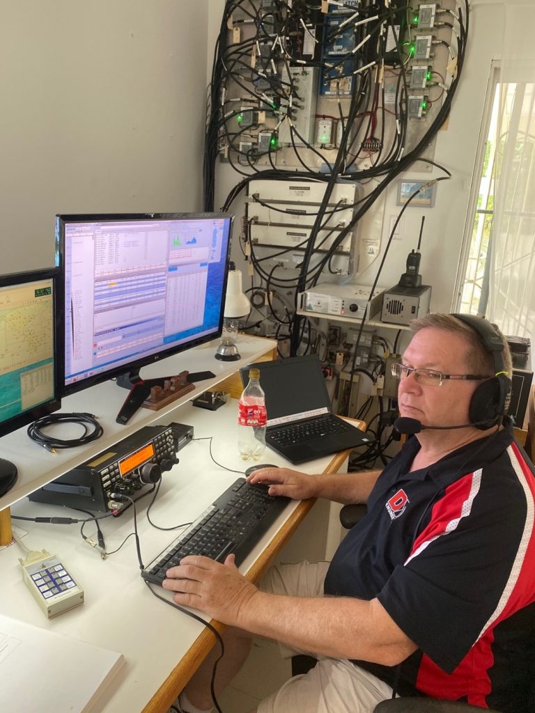 man working at a desktop ham radio station