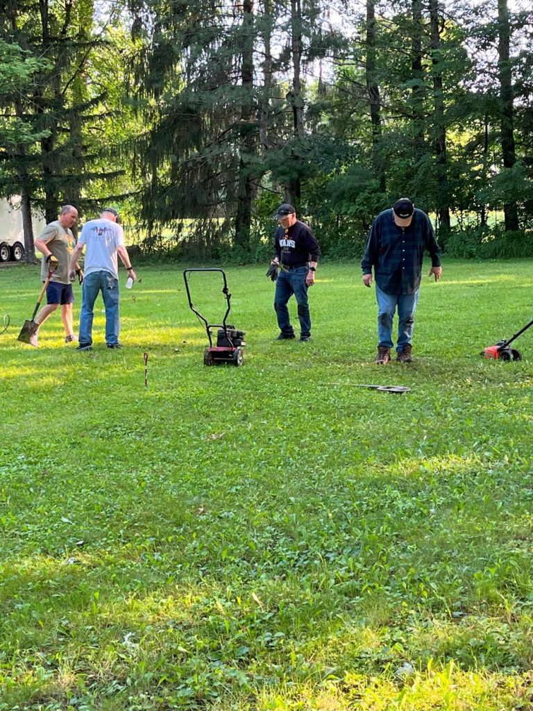 men readying a plot of land to erect an antenna