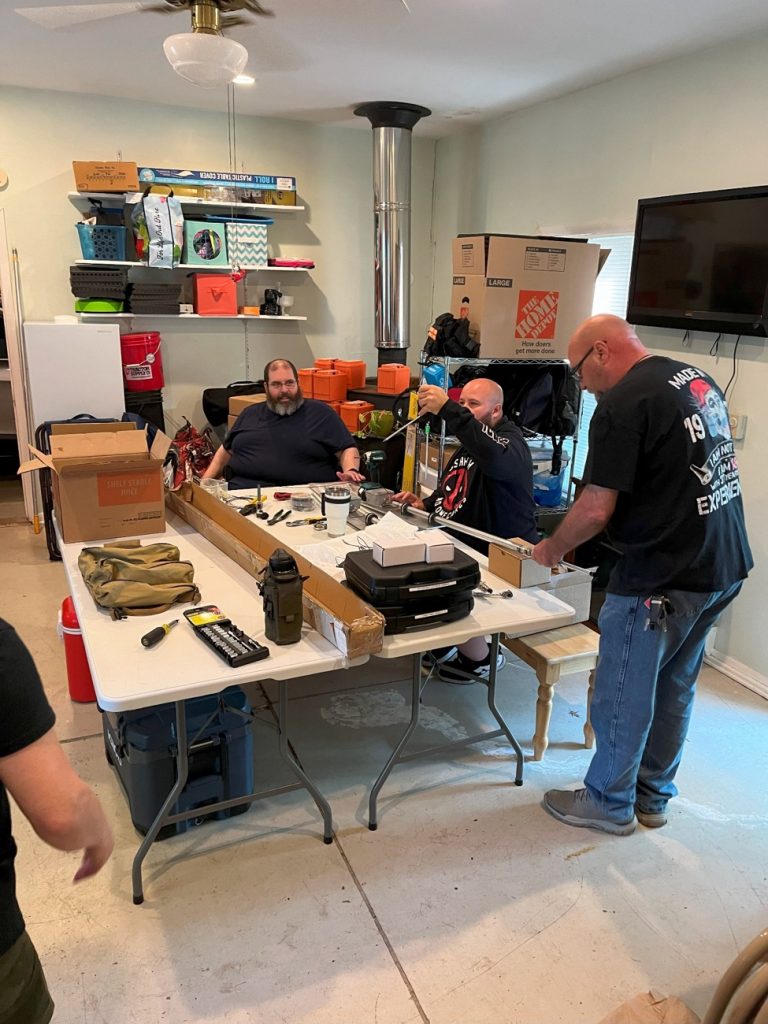 men preparing gear in a small storehouse