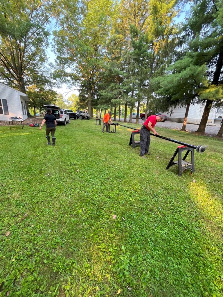men assembling an antenna mast on sawhorses