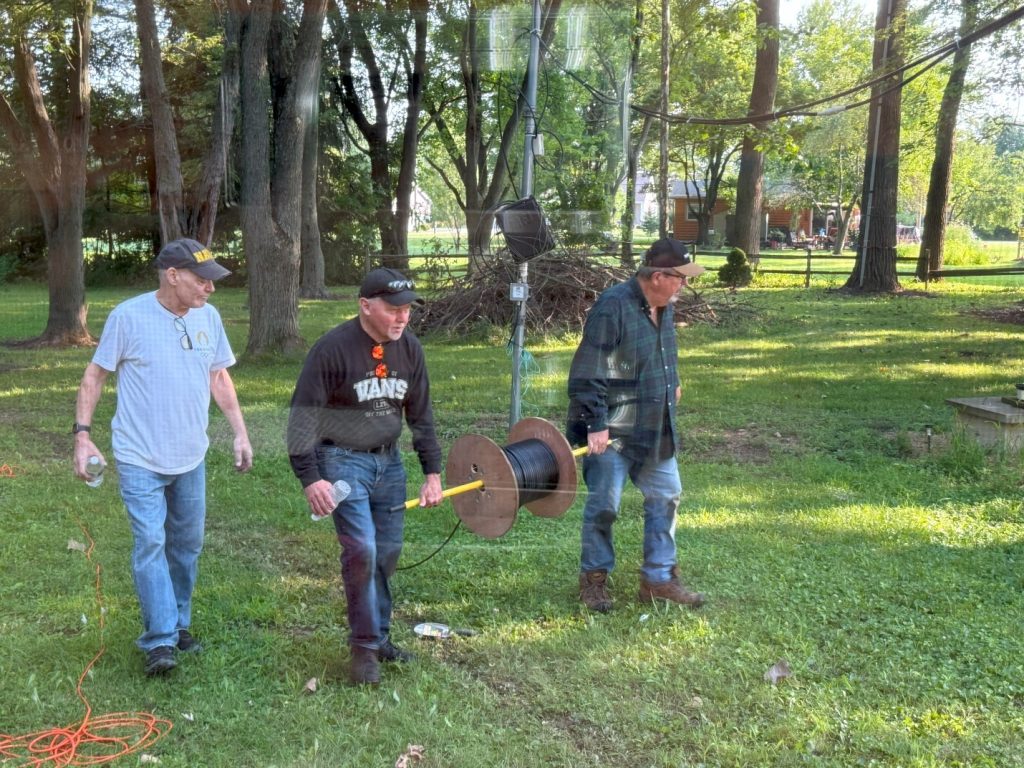 men running coaxial cable off a spool