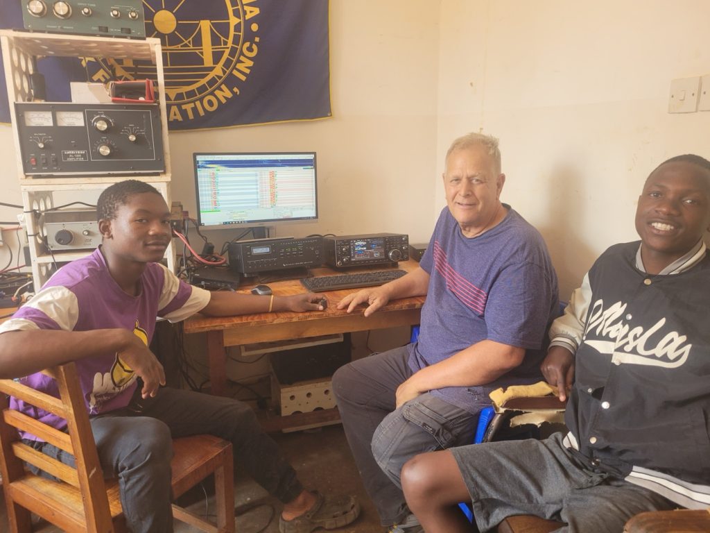 group of ham radio operators at small desktop station