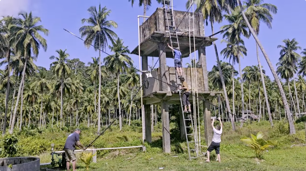 men building an outdoor antenna in jungle