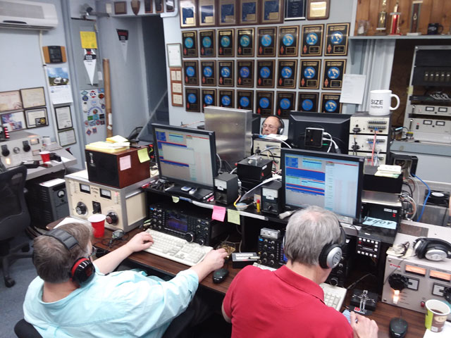 a group of operators in a large ham radio station