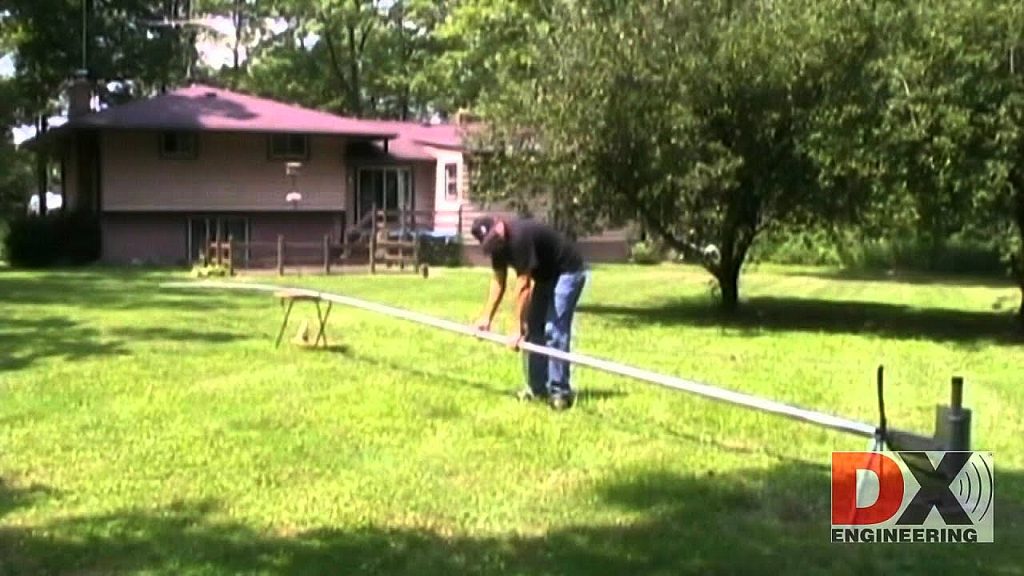Man erecting a large vertical antenna