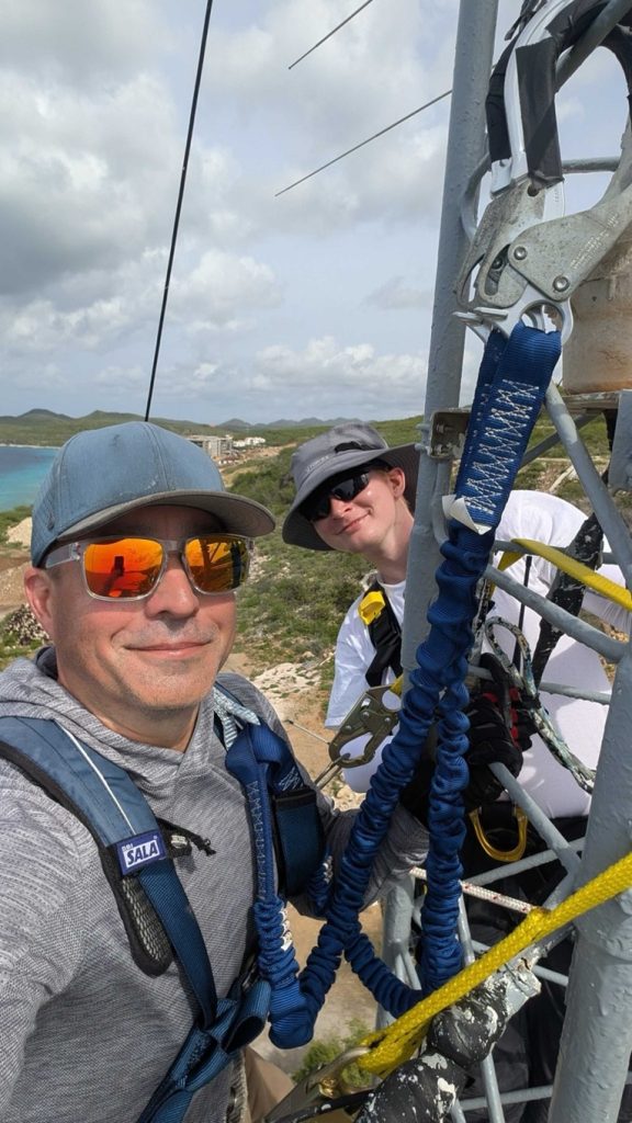 ham radio operators climbing an antenna tower