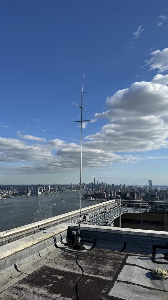 Vertical antenna atop a tall urban building